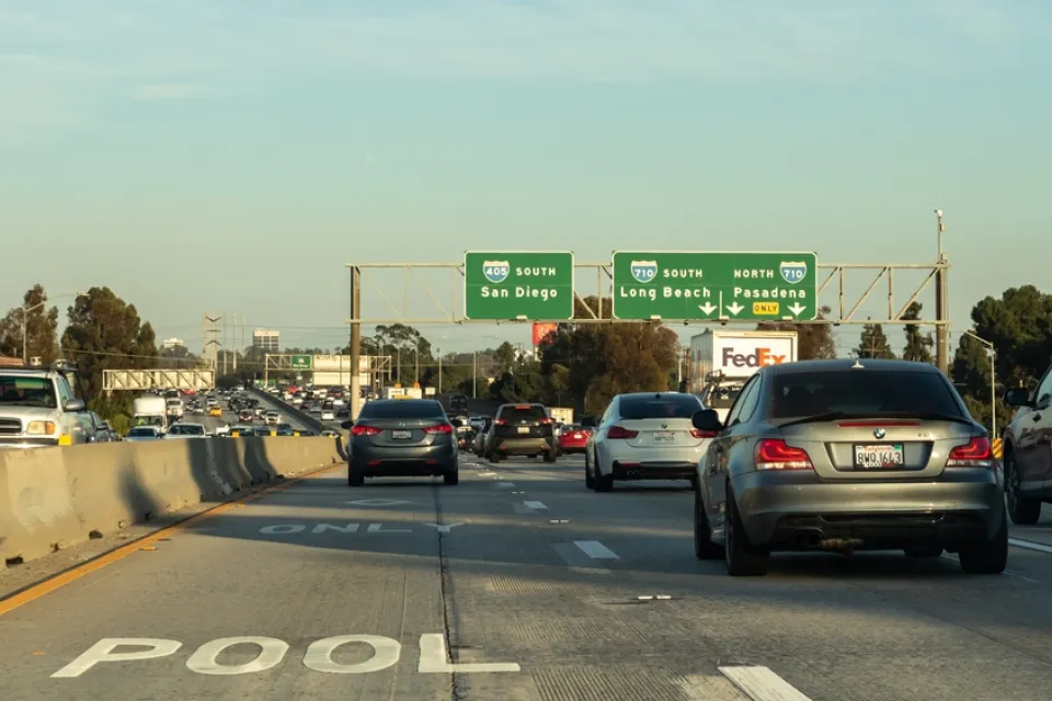 Smog hovers in the air in the background of this image of heavy car traffic on the 405 Freeway near ints intersection with the 710 Freeway in Southern California.